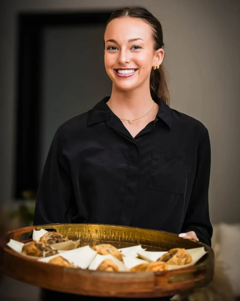 Evolved Catering Baltimore server holding a tray of passed appetizers at an event