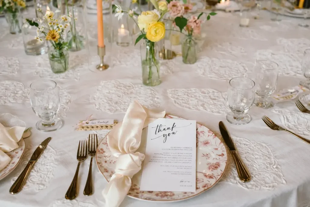 Place setting with printed menu, florals and gold flatware at a booked private event