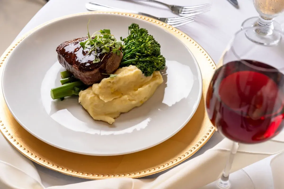 Plated steak with mashed potato and a glass of red wine. Catering in Downtown Baltimore.
