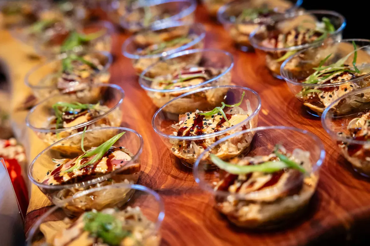 Individual appetizer cups lined up on a wood serving board. Catering in Sowebo, Baltimore.