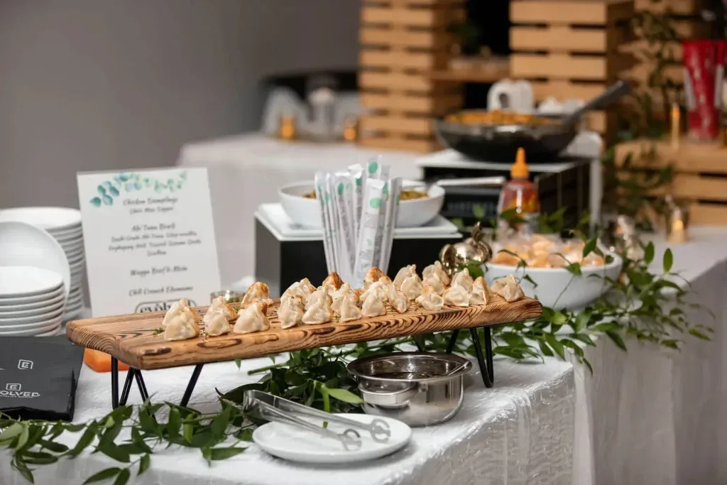 Buffet display board of canapes and appetizers with greenery and menu cards at a catered event