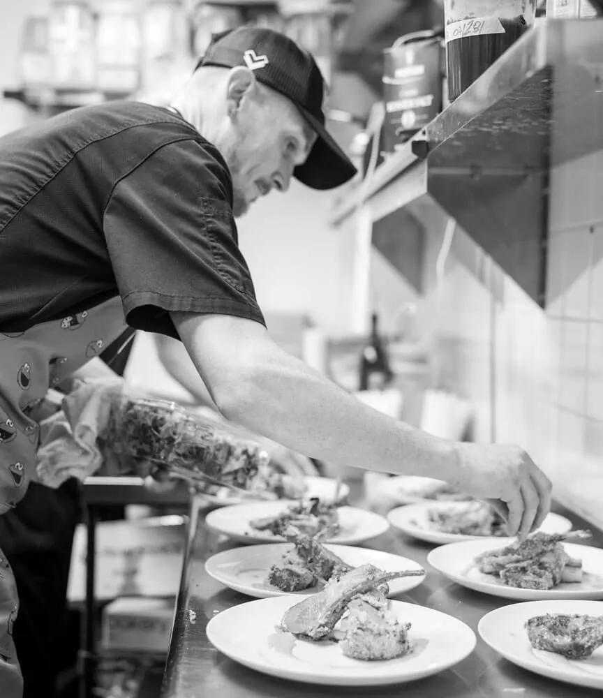 Chef plating dishes on a kitchen counter before service in Baltimore