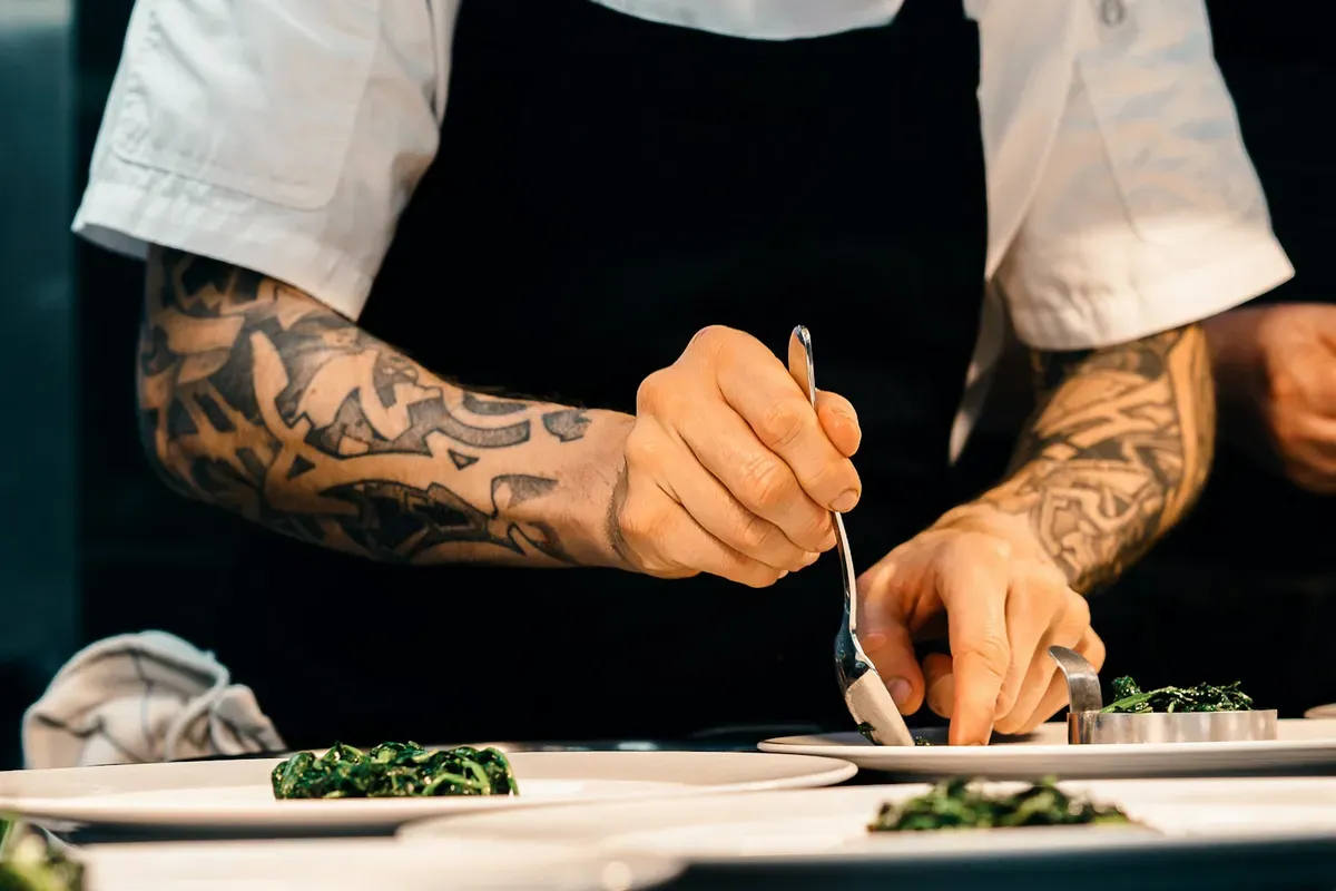 Professional chef carefully plating food before a catered meal