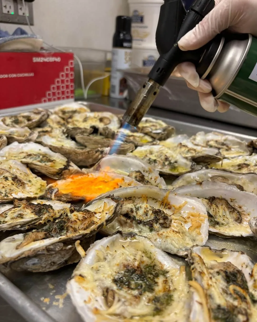 Baked oysters being finished with a torch before serving in Baltimore