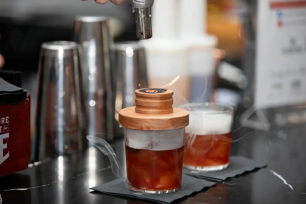 Mixed cocktails and bar tools set out on a bar counter