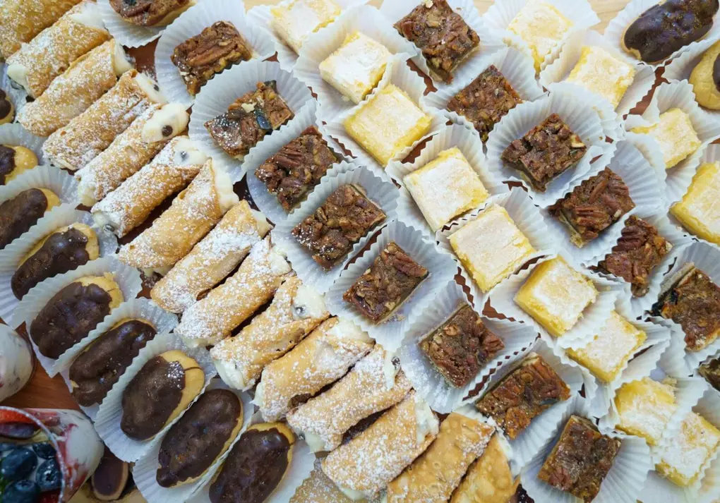Rows of dessert bars on trays at a catered event