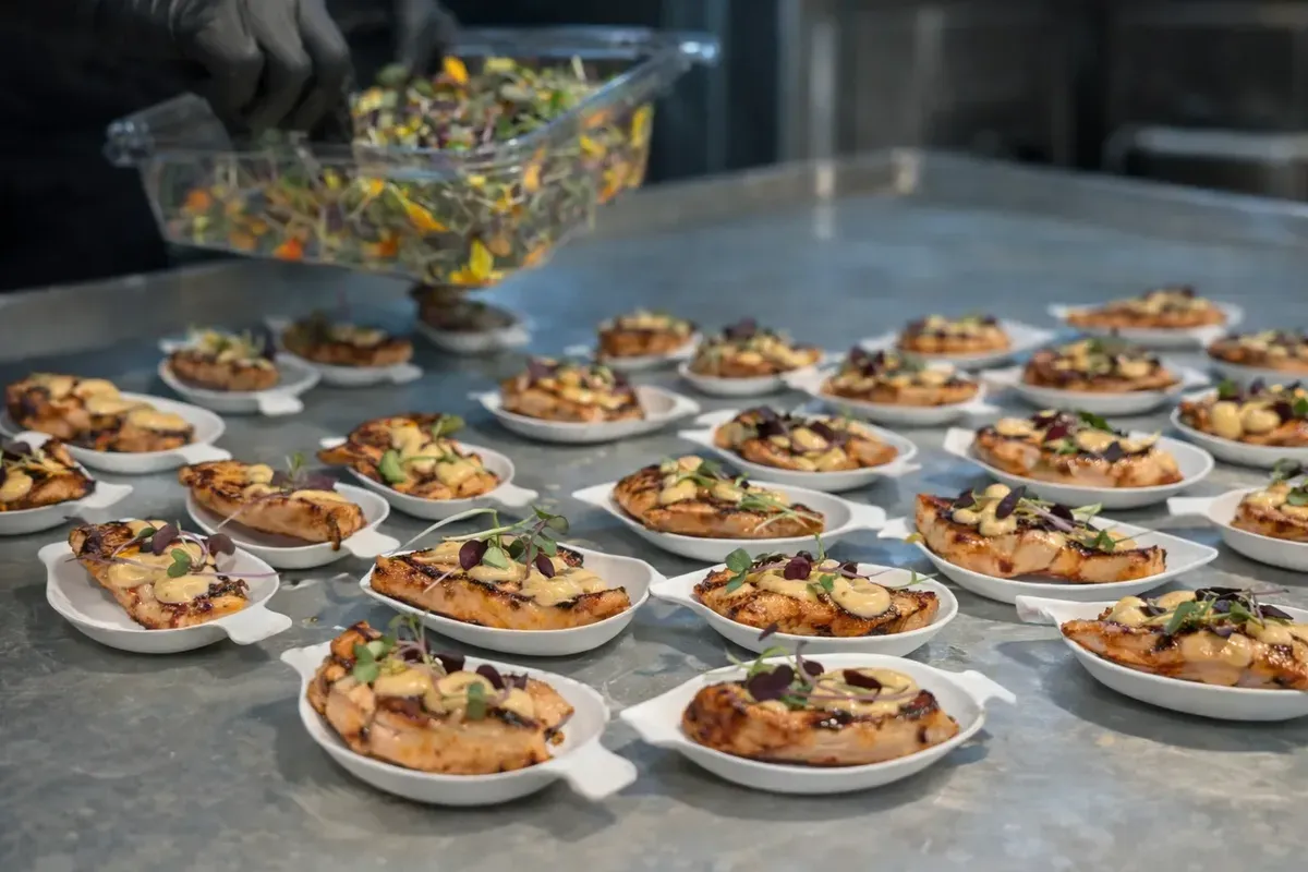 Rows of individual appetizer plates prepared for passed service at a catered event