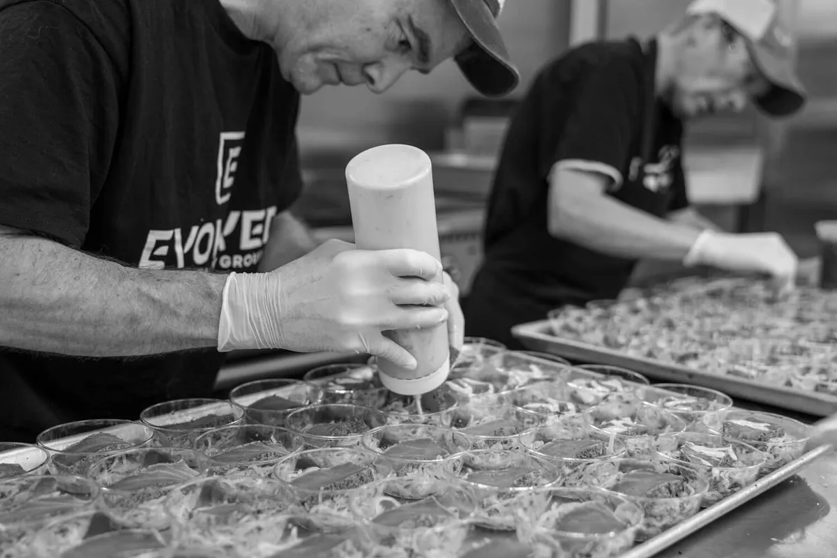 Evolved Catering staff prepping trays of drinks before service in Baltimore