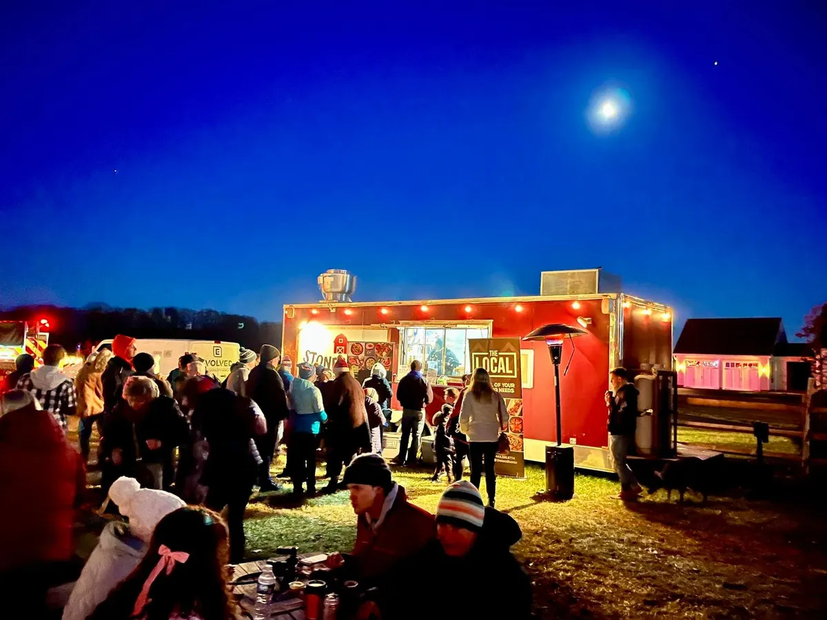 Guests gathered at an outdoor evening event with catered food service in Baltimore
