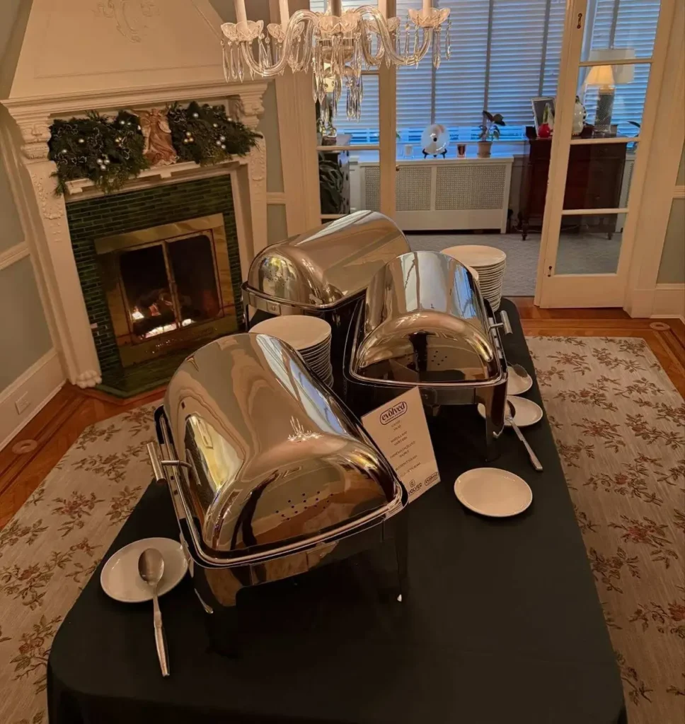 Chafing dishes set on a table in a home dining room for a catered party in Baltimore