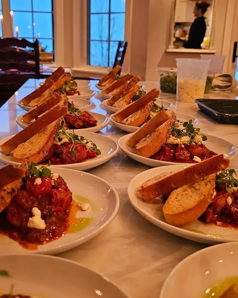 Plated dishes lined up on a table for a catered meal at home in Baltimore