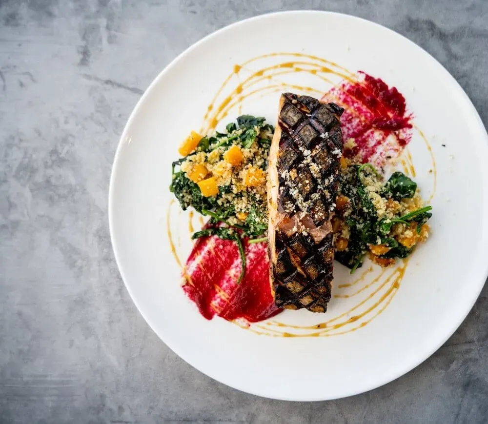 Plated salmon with sauteed greens served as a wedding meal in Baltimore